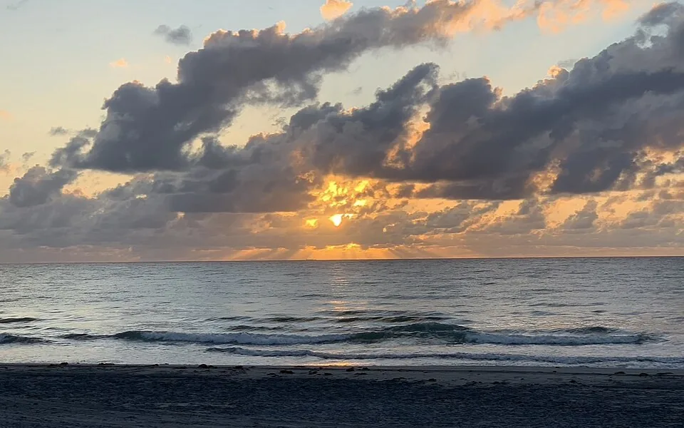 O sol nascendo sobre o mar, na praia de Delray